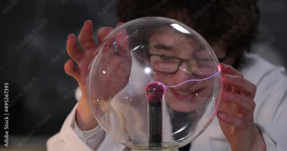 Wall mural schoolboy experimenting in physics class. young student doing physics experiment in the classroom.