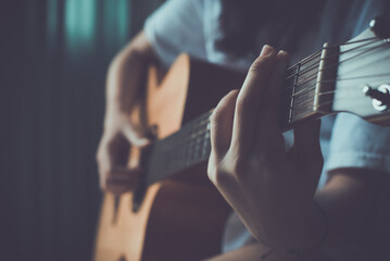 Close up of women hand playing guitar.