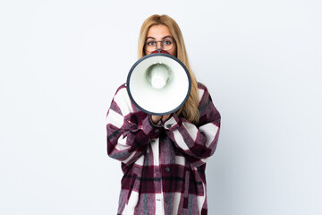 Obraz premium Young Uruguayan blonde woman over isolated white background shouting through a megaphone