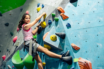 Caucasian active girl playing with happiness and climbing rock mountain with safety for adventure and sport. Activity and Education Concept.