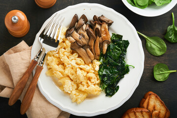 Omelet. Spinach oyster mushroom and cheese omelet or frittata on dark old wooden background. Breakfast idea.  Top view with copy space.