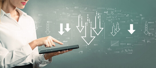 Descending arrows with business woman using a tablet computer
