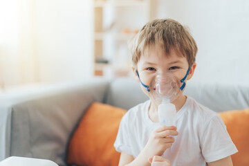 Smiling little boy wearing nebulizer mask close-up. - obrazy, fototapety, plakaty