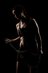Fototapeta na wymiar Strong fit girl with metal chain. Pulling and posing against black background..