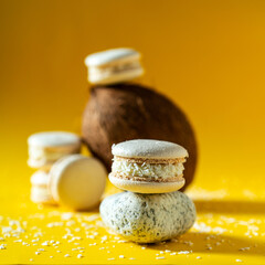 Delicious fresh macaroons with coconut sprinkle on a yellow background