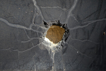 A big world war II bullet hole in the middle of an old crypt on a graveyard in Berlin-City. View...