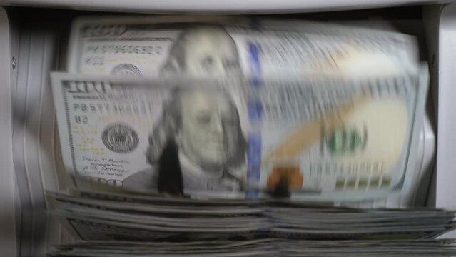 Money counting machine counts 100 dollar bills. Close up shot