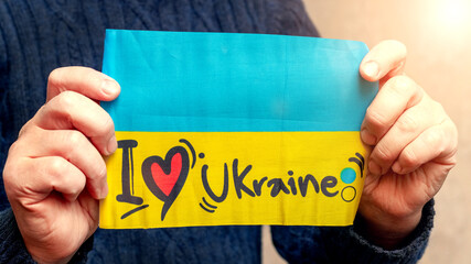 A man holds the flag of Ukraine with the inscription "I love Ukraine"