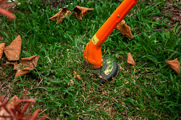 lawn mowe is Gardening care tools and equipment. Process of lawn trimming with hand mower
