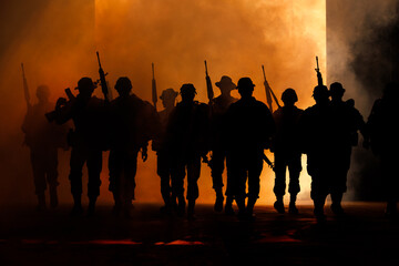 silhouette group of thai soldiers special forces full team in uniform walking action through smoke...