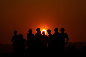 Fototapeta na wymiar silhouette group of special forces sodiers standing and sit on tank with over the sunset background,
