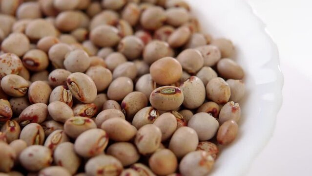 Uncooked gunga beans close up. Pigeon peas. Falling in slow motion. Macro. Rotation