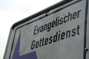 Altes Straßenschild als Hinweis auf einen Evangelischen Gottesdienst