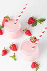 A glass of fresh strawberry smoothie on a white background. Summer drink shake, milkshake and refreshment organic concept.