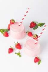 A glass of fresh strawberry smoothie on a white background. Summer drink shake, milkshake and refreshment organic concept.