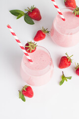 A glass of fresh strawberry smoothie on a white background. Summer drink shake, milkshake and refreshment organic concept.