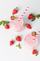 A glass of fresh strawberry smoothie on a white background. Summer drink shake, milkshake and refreshment organic concept.