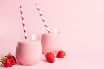A glass of fresh strawberry smoothie on a pink background. Summer drink shake, milkshake and refreshment organic concept.