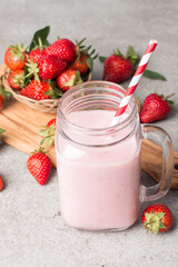 A glass of fresh strawberry smoothie on a pink background. Summer drink shake, milkshake and refreshment organic concept.