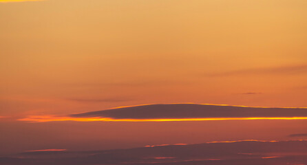 Beautiful dark golden sunset sky with clouds. Sky background.