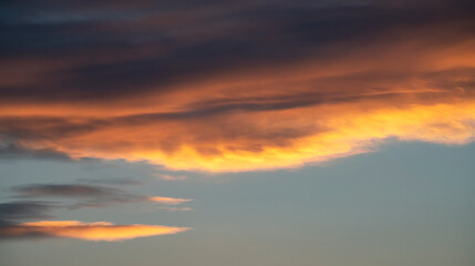 Beautiful dark golden sunset sky with clouds. Sky background.