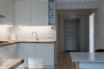 white kitchen, white cabinets and solid wood worktop, gas stove and faucet.