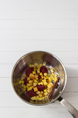 Ingredients fruit topping in saute pan on white background.