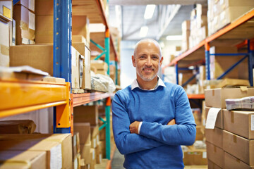 I do a great job and I know it. Portrait of a warehouse employee standing beside shelving filled with boxes.