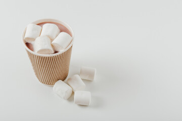 Paper cup with hot drink with marshmallows. White background. Coffee, latte, cappuccino, cocoa. Disposable  paper cup. Recycling and eco friendly concept.