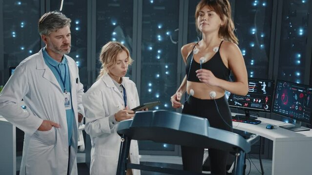 Data center. Running marathon female athlete exercising on treadmill in server room. Couple of physicians checking her health and endurance. Science laboratory. Sports.