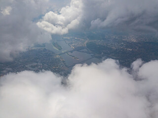 Fototapeta premium Kyiv city through high clouds. Cloudy day. Aerial drone view.