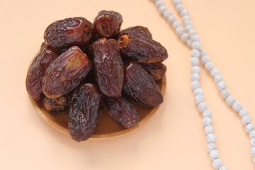 Fresh date fruits and white prayer beads, ramadhan concept idea. Sitting view. Vibrant color date...