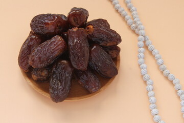 Dried date and white prayer beads, ramadhan concept idea. Sitting view. Vibrant color fruits...