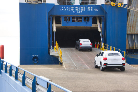 Autoverladung:  Autos fahren &uuml;ber eine Rampe in ein gro&szlig;es RoRo-Schiff (Roll-on/Roll-off)