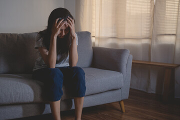 Obraz premium Asian woman covering her face feeling sorrow and depressed sit in the dark bedroom