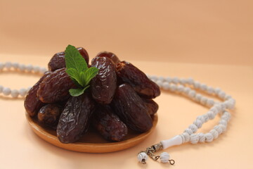 Fresh date and white prayer beads, ramadhan concept idea. Sitting view. Vibrant color fruits prepared for iftar.