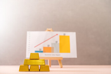 Gold bar and board graph with growing value for invest put on the desk in the office, Targeting of...