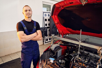 Repairing a car engine in auto-service center. Auto mechanic working in the garage