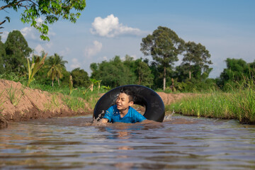 Children playing and swimming in canal of organic farm 