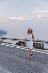 woman in white dress walking by speedway road