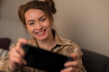 Mobile games on a portable game console. A cute girl plays video games. Close-up. Fun...