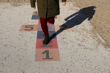 Hopscotch game - shadow of a jumping girl