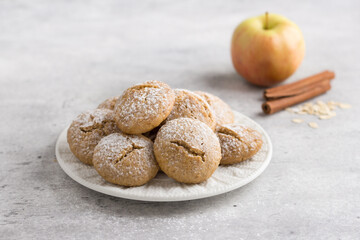 Steamed oatmeal cookies with apple and cinnamon sprinkled with powdered sugar on light gray...