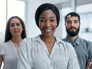 Collaborations are highly valued in my company. Portrait of a businesswoman standing in an office with her colleagues in the background.