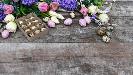 Fototapeta na wymiar Wachteleier mit Blumenarrangement auf altem Holz.