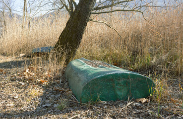 Old broken boat thrown on the shore of the lagoon by the waves during a strong storm. A dirty and...
