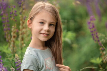 little girl among a field of blue flowers