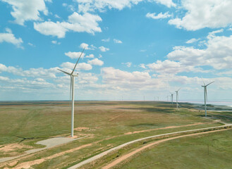Panoramic View of Wind Turbine Farm on agricultural field with blue cloudy sky in Ukraine.