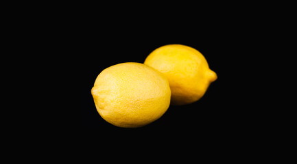 Ripe lemons on the black background. Close-up. Copy space.