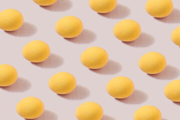 Pattern of yellow eggs on a cream background. The concept of minimal food.Easter eggs.